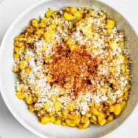 Elotes · Corn in a cup with mayo chipotle sauce, taijin, lime juice, and Cotija cheese.
