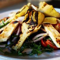 Artichoke · Grilled Roman artichoke hearts served over baby arugula, cherry tomatoes, and red onion topp...
