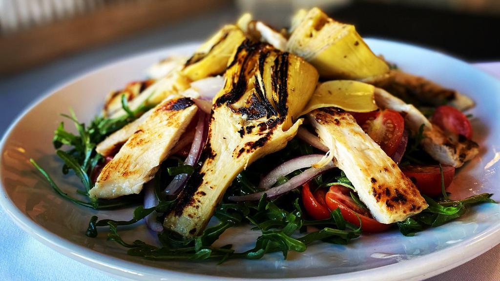 Artichoke · Grilled Roman artichoke hearts served over baby arugula, cherry tomatoes, and red onion topped with shaved parmigiana served with whipped lemon, herb, and olive oil dressing.