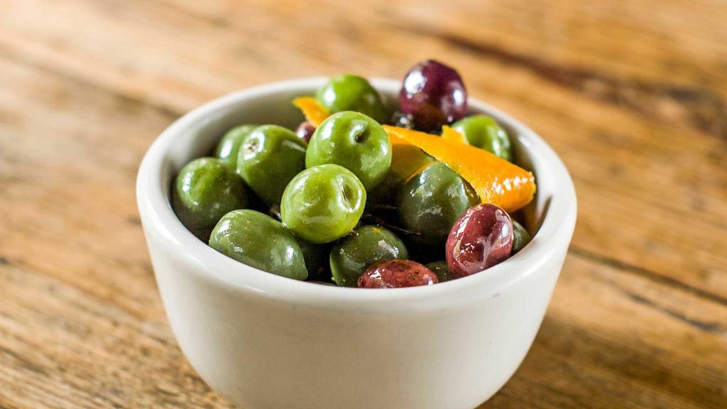 Marinated Olives · Gluten-free, dairy free. Cerignola, black geata, and castelvetrano olives marinated in orange zest, and juice, red pepper, rosemary, garlic and olive oil.