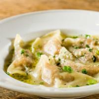 Sweet Potato Ravioli With Sage In Parmesan Broth · Half-moon sweet potato ravioli served in a thin cheese broth and garnished with sliced scall...