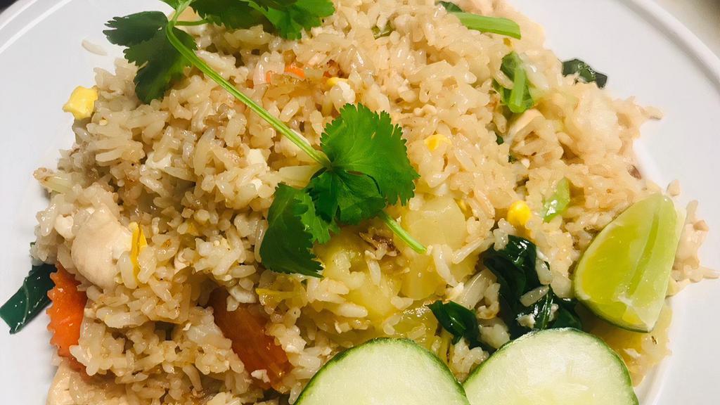 Pineapple Fried Rice · Stir fried jasmine rice with egg, onions, scallions, Chinese broccoli, carrots, tomatoes, and pineapples.