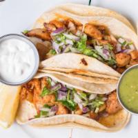 Chipotle Chicken Tacos · Two tacos. Served with chopped onions, cilantro, sour cream, and salsa verde.