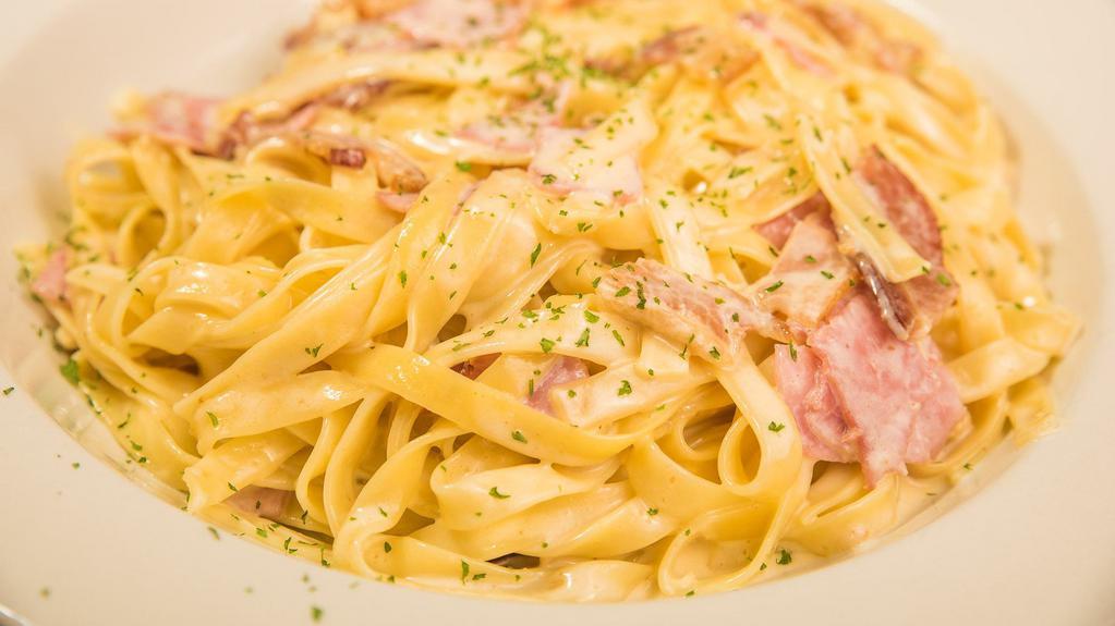 Fettuccine Carbonara · Served with ham, bacon, and mushrooms, in an Alfredo sauce. Served with a cup of soup or salad, and garlic roll.