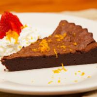 Chocolate Cake · Flourless with Orange Zest on top and a side of Whipped Cream and Strawberry