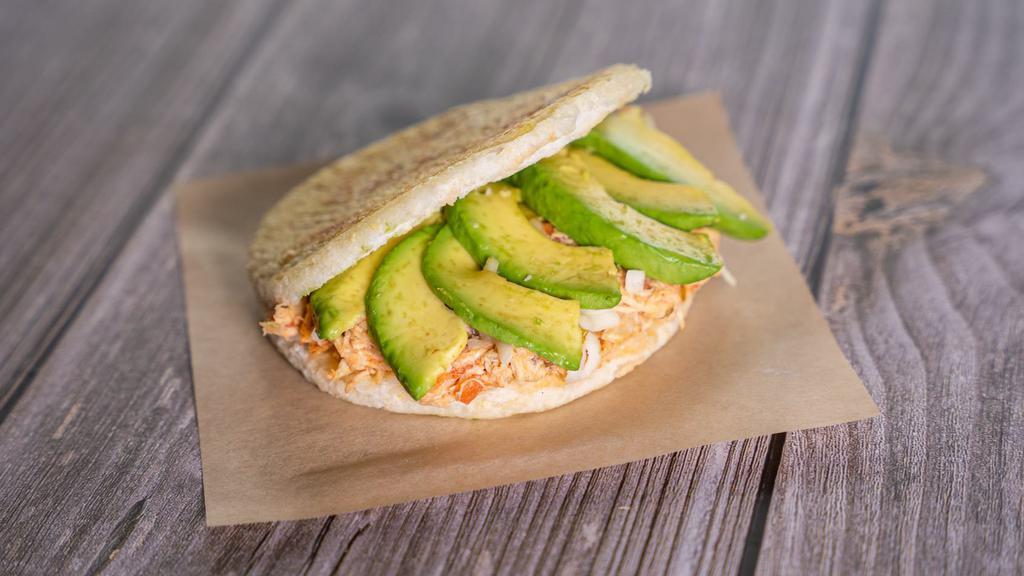 Arepa De Desmechada De Pollo · Arepa con pollo desmechado, queso y aguacate. /
• corn cake, shredded chicken, cheese, and avocado.