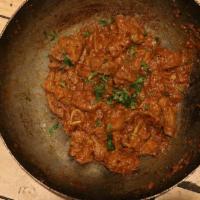 Maula Jutt Mutton Karahi · Stir-fried Mutton with tomatoes, ginger in a wok like pan, topped with cilantro and green ch...