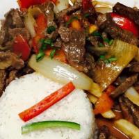 Lomo Saltado · Strips of steak sautéed with tomatoes, onions, soy sauce, wine, and spices served on top of ...