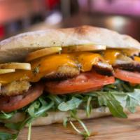 Chicken Sandwich · Breaded chicken, cheddar cheese, sweet apple, plum tomatoes, arugula, homemade pesto on a to...