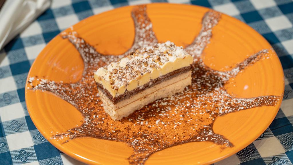 Torta Nocciola · Alternating layers of hazelnut cake, hazelnut cream and chocolate cream, topped with praline hazelnuts