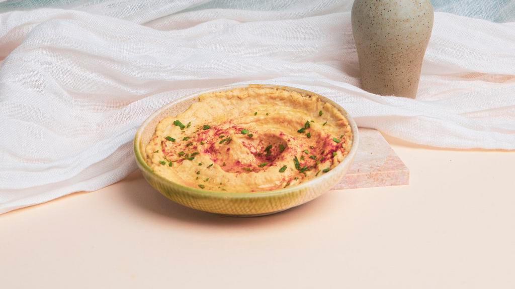 Hummus · Garbanzo beans blended with fresh garlic, lemon juice, and tahini drizzled with extra virgin olive oil. Served with pita.