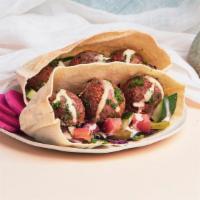 Classic Falafel Pita Sandwich · Falafel with shredded cabbage, diced tomato and cucumber, and a tahini drizzle wrapped up in...