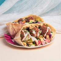 Ultimate Falafel Pita Sandwich · Falafel with hummus, french fries, shredded cabbage, diced tomato and cucumber, and a tahini...