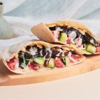 Eggplant Hummus Pita Sandwich · Grilled eggplant with hummus, shredded cabbage, diced tomato and cucumber, and a tahini driz...