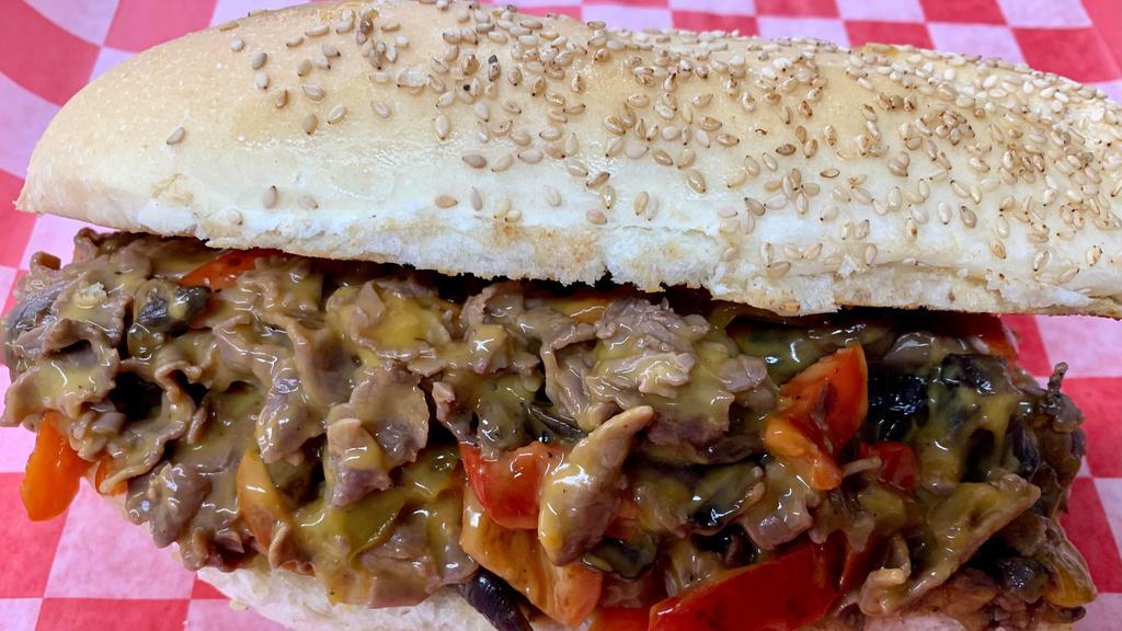 Philly Cheese Steak Sub · Sliced thin tender beef with Onions, Red and Green Peppers and Cheddar Cheese Sauce piled up on a Fresh Grilled Sub Roll.