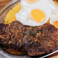 Bife A Portuguesa · Pan-fried steak topped with two eggs over easy and served with french fries and rice.