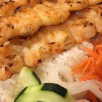 Grilled Shrimp Over Rice · Grilled shrimp with carrot, cucumber, and white radish on top of white rice.