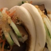 Melt In Your Mouth Pork Belly · Two pieces of steamed bun sandwich with pork belly, carrot, cucumber, cilantro, and peanuts.
