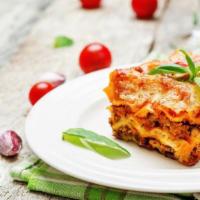 Lasagna · Italian classic dish made with fresh marinara sauce, meat, all oven-baked. Served with a sid...