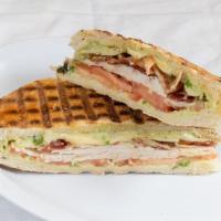 Turkey Panini · Turkey with basil avocado aioli, tomatoes, fontina cheese and bacon. Served with chips.