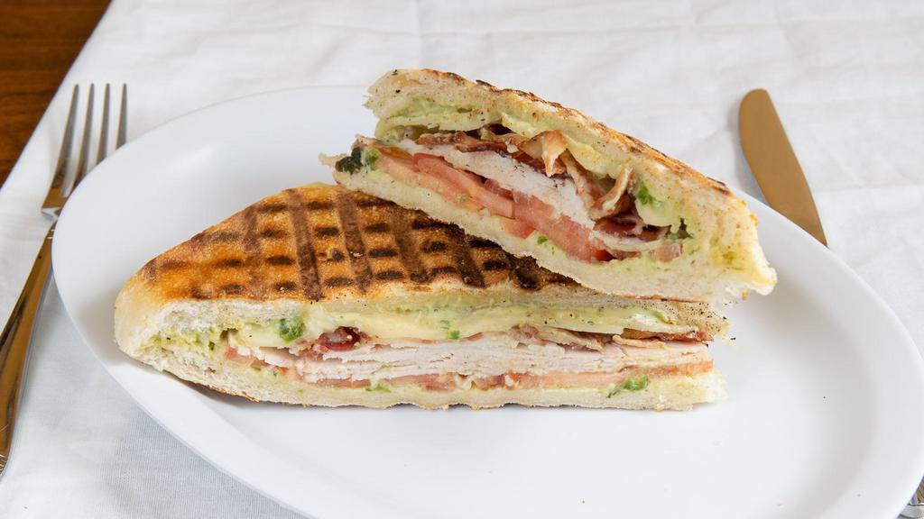 Turkey Panini · Turkey with basil avocado aioli, tomatoes, fontina cheese and bacon. Served with chips.