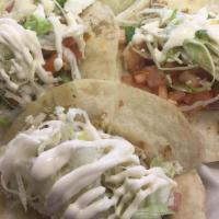 Mini Beer-Braised Chicken Tacos · Topped with pico de gallo, queso fresco and crema.