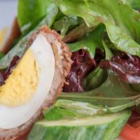 Scotch Eggs · Hard-boiled eggs rolled in sausage roll mince & breaded w/ hazelnuts over organic baby greens.
