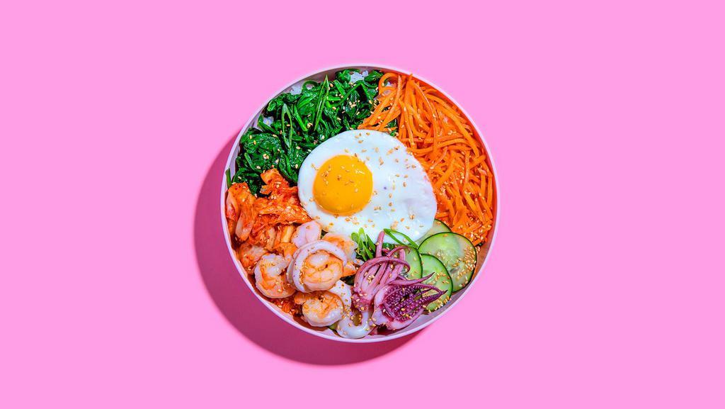 Seafood Bibimbap · Shrimp and squid with white rice, kimchi, shredded carrots, cucumber, scallions, sesame seeds, fried egg, and gochujang.