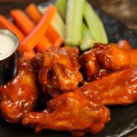Classic Buffalo · 8 classic buffalo wings* (medium heat), served with carrots & celery and a choice of blue ch...