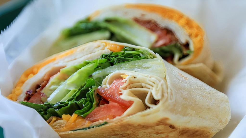 California Turkey Wrap · Delicious Wrap made with Sliced grilled turkey, avocado, plum tomato, romaine lettuce and cilantro with sour cream, served on a wheat wrap.