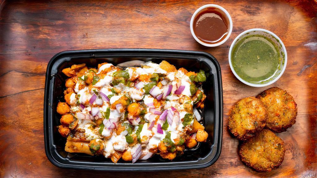 Aloo Tikki Chaat · Crispy aloo tikki served with chickpeas masala, yoghurt, tamarind date, cool mind and coriander chutney. Topped with tomatoes, onions, cilantro, chickpea noodles and spice blend.