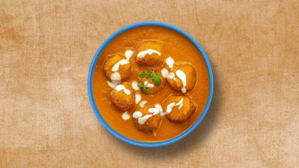 Cottage Cheese Treasure · Fried balls of potato and cottage cheese in a rich and creamy mild gravy with sweet onions and tomatoes. Served with a side of rice.