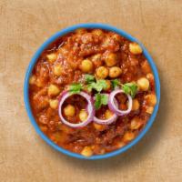 Courtyard Chickpea Masala · Chickpeas cooked in juicy onions, tomatoes, and perfectly grounded spices. Served with a sid...