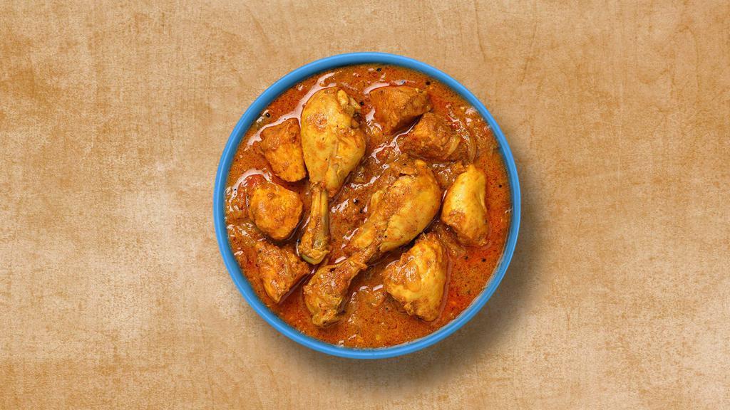 Classic Chicken Curry · Chicken simmered in a curry sauce with yogurt, tomatoes, onion, garlic, and ginger. Served with a side of rice.