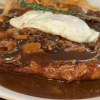 Bitoque · Steak in demi-glace sauce topped with egg served with French fries rice and beans.