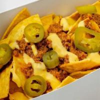 Nachos · Homemade chili (ground beef) served with cheddar cheese sauce, freshly made tortillas chips ...