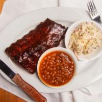 Baby Back Ribs · Marinated. Slow-cooked grilled and sauced. Served with beans and slaw.