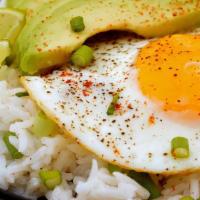 Rice Bowl With Fried Egg And Avocado · Three fried eggs with corn, black beans and avocado over cilantro lime rice.