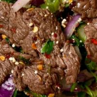 Neua Yang Nam Tok (Beef Salad) · Thai grilled slices beef salad with scallion, onion, mint leaves in lime juice dressing.