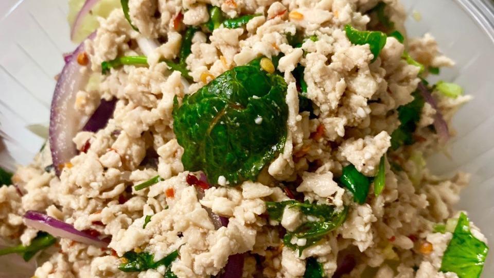 Larb Gai (Chicken Salad) · Steamed minced chicken with scallion, onion, mint leaves, ground roasted rice, chili in spicy lime juice dressing.