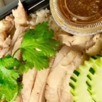 Khao Man Gai · Steamed chicken over ginger rice served with Thai herbs ginger sauce.