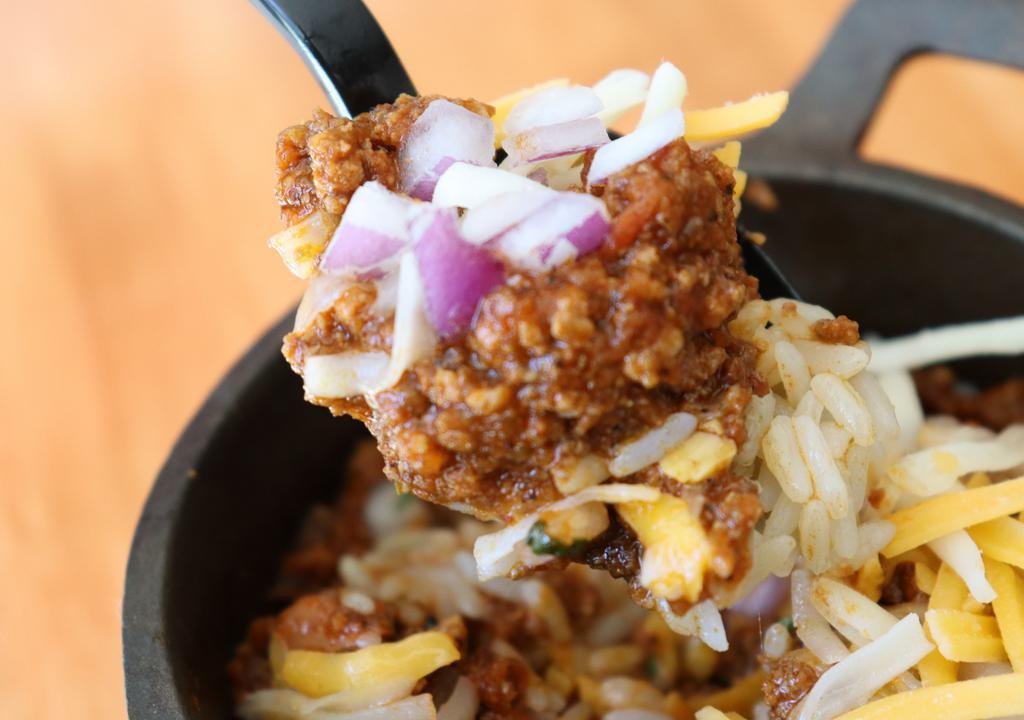 Spicy Beef Chili · With chopped onion and shredded cheese.