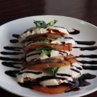 Caprese Salad · Fresh mozzarella cheese, beef steak tomatoes, and basil, served in traditional style.