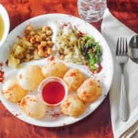 Pani Puri Chaat · A crispy puffed up puri with a chickpea and spiced potato stuffing served with spicy mint an...