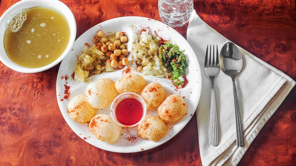 Pani Puri Chaat · A crispy puffed up puri with a chickpea and spiced potato stuffing served with spicy mint and coriander water and sweet tamarind chutney.