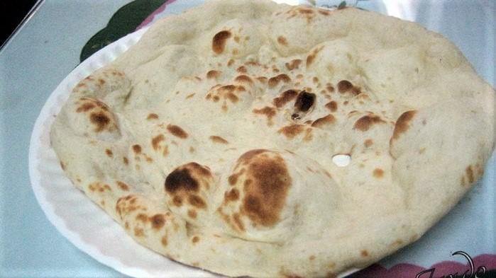 Naan · Soft white flour bread, freshly baked in tandoor.