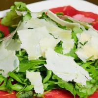 Beef Carpaccio · Baby arugula, shaved Parmesan cheese and extra virgin olive oil.