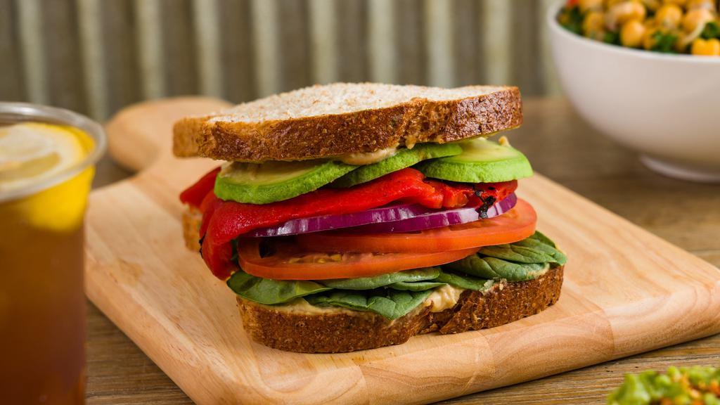 Avocado Veggie (Vegan) · Tomatoes, Red Onions, Baby Spinach, Sliced Avocado, Roasted Peppers, Hummus on Whole Wheat Toast.