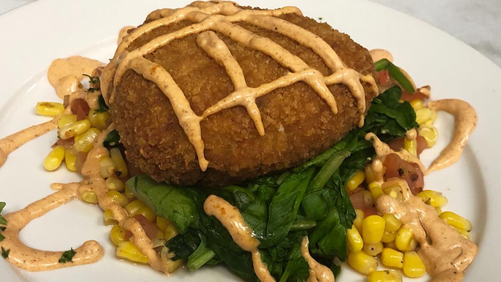 Lump Crab Cake · Crab cake over sautéed spinach, corn and tomato topped with Cajun remoulade.