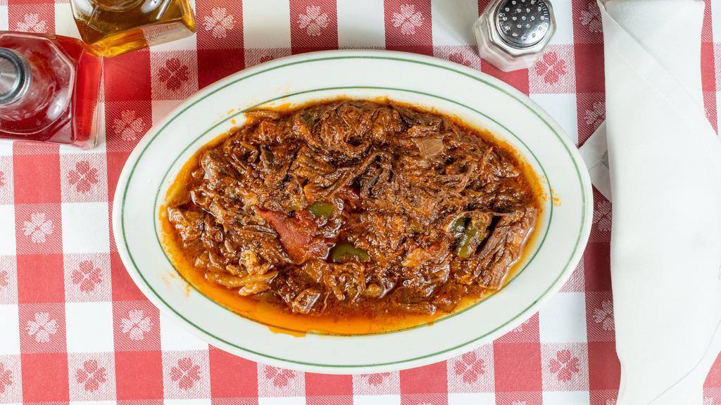 Ropa Vieja · Shredded flank steak simmered in tomato sauce with onions and peppers.